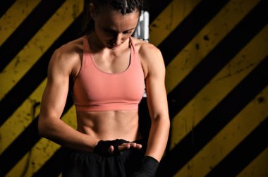 Genç bir kadın spor salonunda şınav çekiyor.