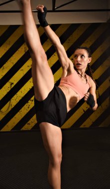 Spor salonunda halterle egzersiz yapan genç bir kadın.