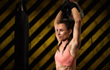 Spor salonunda egzersiz yapan genç bir kadın.