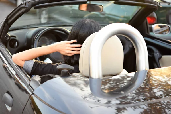 市内でスポーツ車を運転若いおしゃれな女性 — ストック写真
