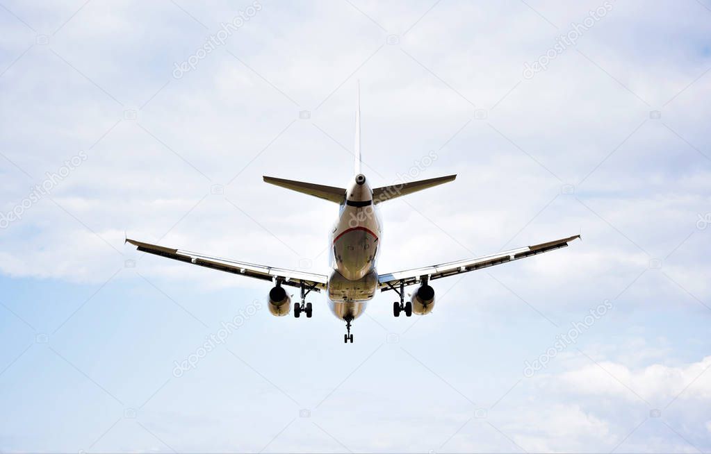 Commercial passenger jet airliner is landing approaching the airport. Travel tourism concept. 