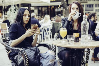 bir kafede oturan iki kadın arkadaş