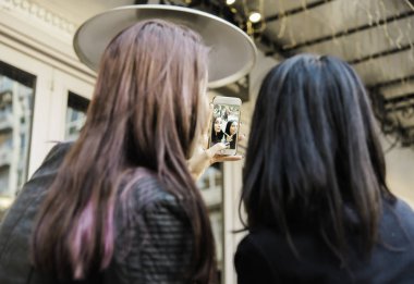 selfie alarak bir kafede oturan iki kadın arkadaş