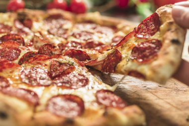 Peynir ve rustik ahşap bir masa üzerinde erime ile sıcak pizza