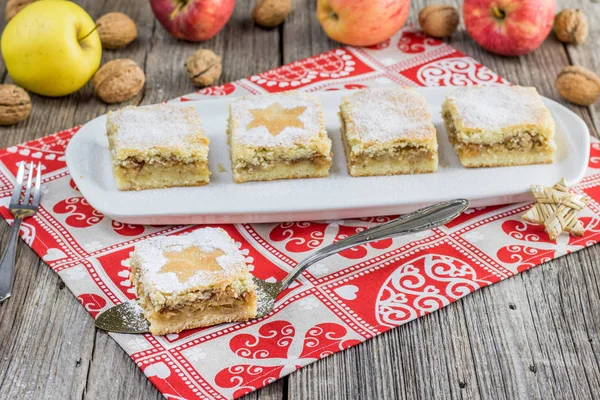 Tereyağlı elma tatlı ceviz ile eski bir masa örtüsü üzerinde kesmek. 