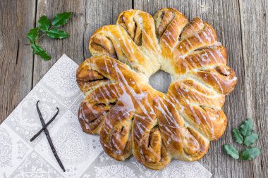 Noel tarçın çelenk tatlı ile vanilya pod ve holly dal ahşap bir gemide - üstten görünüm