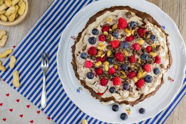 Vanilya krem ve orman meyve beyaz plaka üzerinde bir Pavlova pastayı üstten görünüm