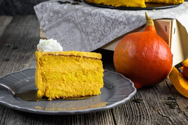 Detail on a Slice of Pumpkin cake with caramel cream and whipped cream on gray plate