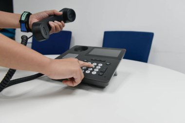 IP telefon el ayarla ve arama için Sayı takımını koymak iş kadın elini tutuyor