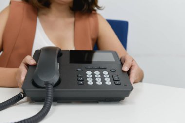 İş kadın siyah IP telefonu tutuyor