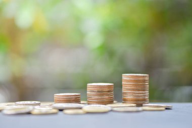 Madeni para yığınları para kavramı kaydetmek için yeşil doğa arka plan ile büyüyen