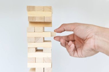 Adam el blok beyaz ekran arka plan üzerinde yuvarlanan kuleden dışarı koymak