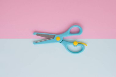 En az düz mavi makas kavramı kopya alanı ile renkli arka plan üzerinde yatıyordu