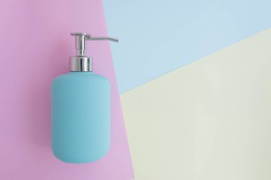 En az düz renkli arka plan üzerinde mavi duş jeli, şampuan veya Kozmetik şişe kavramı kopya alanı ile yatıyordu.