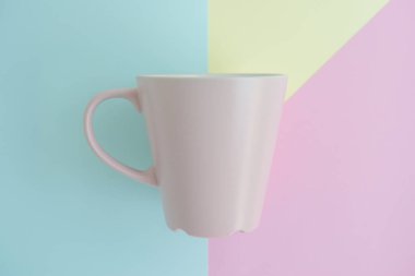 En az düz renkli arka plan üzerinde pembe kahve fincanı kavramı kopya alanı ile yatıyordu.