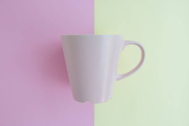 En az düz renkli arka plan üzerinde pembe kahve fincanı kavramı kopya alanı ile yatıyordu.