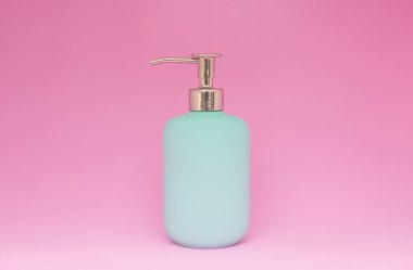 Kopya alanı ile renkli pembe arka plan üzerinde mavi duş jeli, şampuan veya kozmetik şişesi minimal kavramı