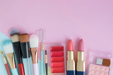 Kopya alanı ile renkli arka plan üzerinde fırça, yanak fırçası, ruj ve kırmızı tonlu ruj paleti mayıs türü için kadın dekoratif kozmetik Düz yatıyordu