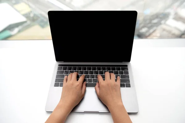 女性手的顶视图是在笔记本电脑键盘上打字 — 图库照片