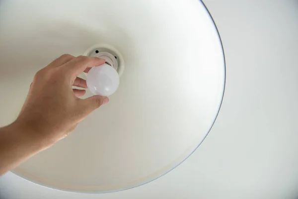 Menschliche Hand wechselt die Glühbirne zu LED für Energiesparkonzept — Stockfoto