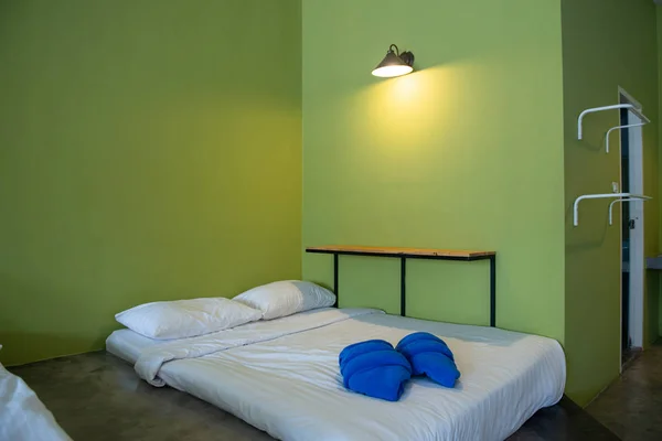 Valkoinen patja ja pyyhe hostellissa Resort huoneessa vihreä wa — kuvapankkivalokuva