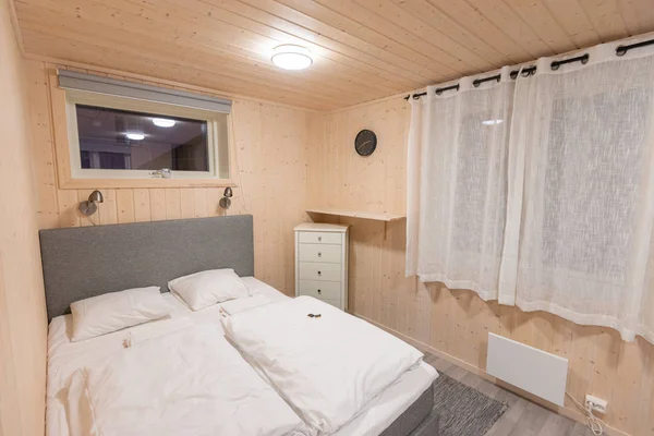 Кровать с белым одеялом и подушкой в маленькой современной хижине — стоковое фото