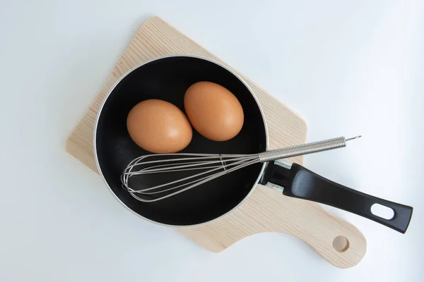Panela com ovo e ovo de aço inoxidável whisk e picar no w — Fotografia de Stock
