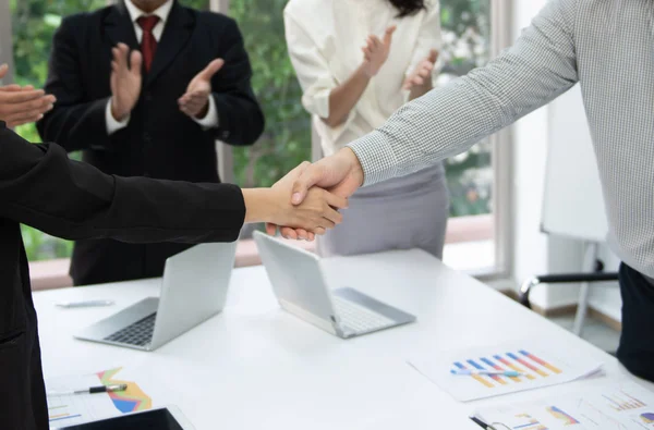 Bedriftsfolk håndhilser på møtet for å håndtere virksomheten – stockfoto