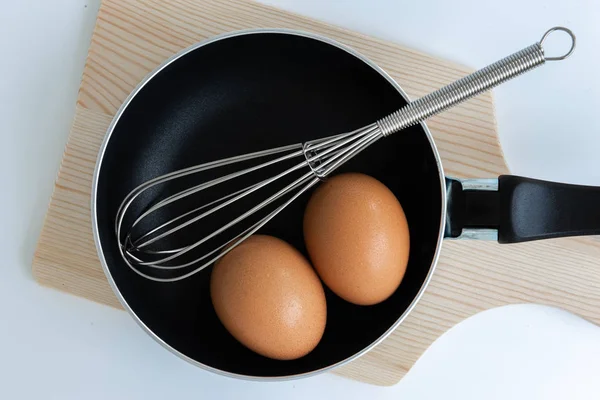 Close up pan com ovo e ovo de aço inoxidável whisk e picar — Fotografia de Stock
