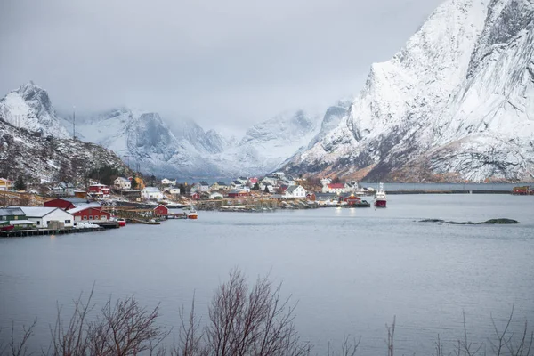 Casa di pescatori villaggio tra la neve con vista sulle montagne in Lofot — Foto Stock