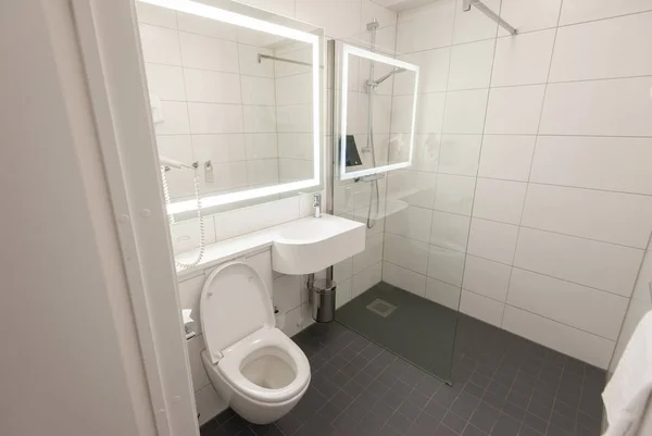Interior do banheiro de luxo com vaso sanitário nivelado, vidro e lavatório — Fotografia de Stock