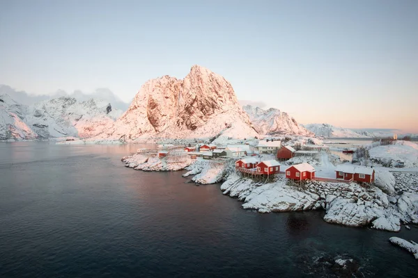 Rosso villaggio di casa di pescatori tra la neve con vista sulle montagne in L — Foto Stock