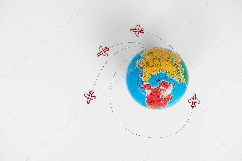 Globe model with air plane paper clip flying circle  on the whit