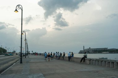 İnsanlar gün batımında Malecon boyunca