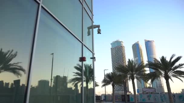 Skyscrapers and palm trees are reflected in the building — Stock Video