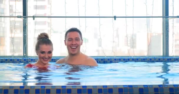 Excité couple rit et câlins dans l'eau de la piscine — Video