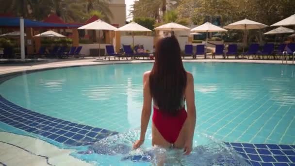 Fille en maillot de bain rouge va dans la piscine — Video