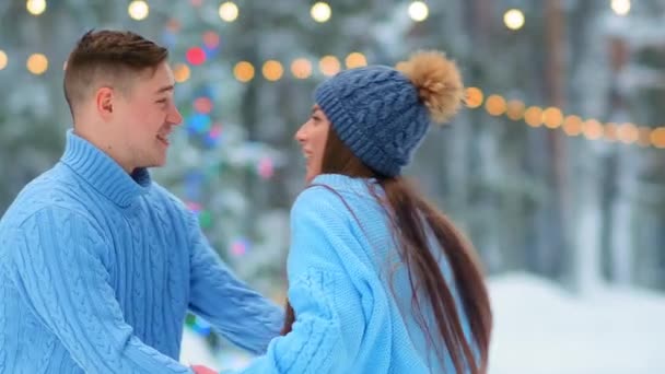 Encantadora pareja en suéteres abrazos y besos en pista de patinaje — Vídeos de Stock