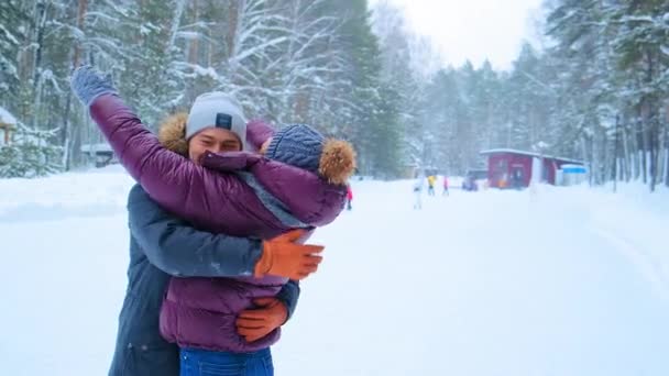 Pozitív emberek dzsekiben ölelés és kéz a jégpályán — Stock videók