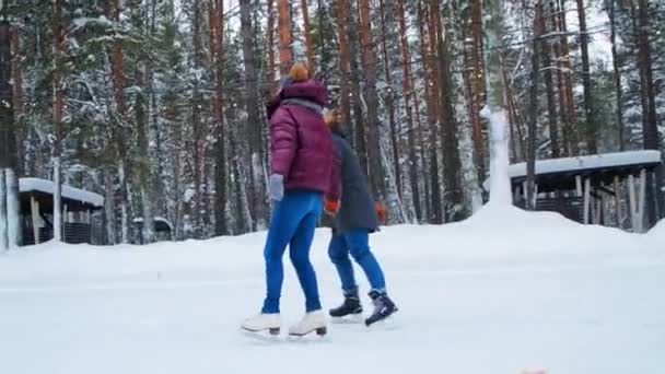 Chica en chaqueta púrpura y chico skate uniendo las manos a lo largo del anillo — Vídeo de stock