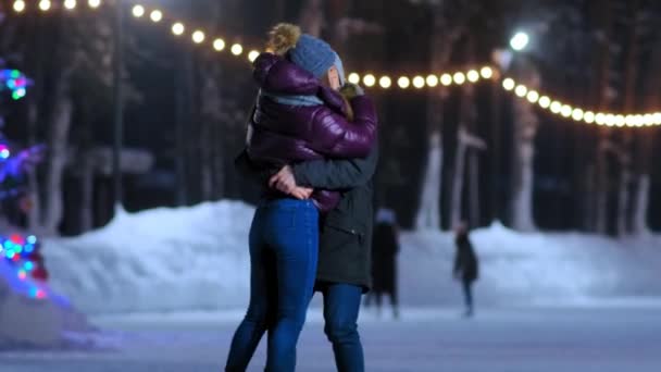 Novio levanta chica en chaqueta corta divertirse en la pista de patinaje — Vídeos de Stock
