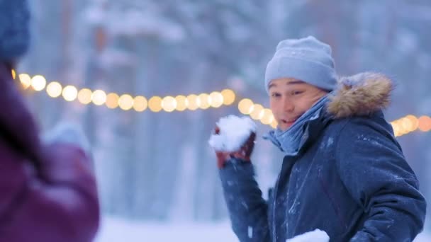 Uśmiechnięty facet i dziewczyna grać śnieżki na lodowisku publicznym — Wideo stockowe