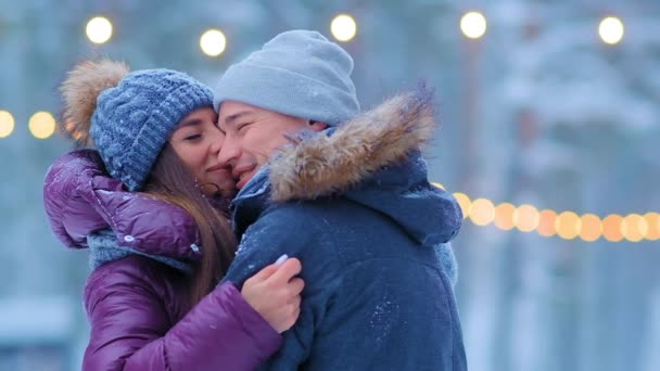 Pria dan gadis dalam jaket hangat pelukan berdiri di arena skating — Stok Video