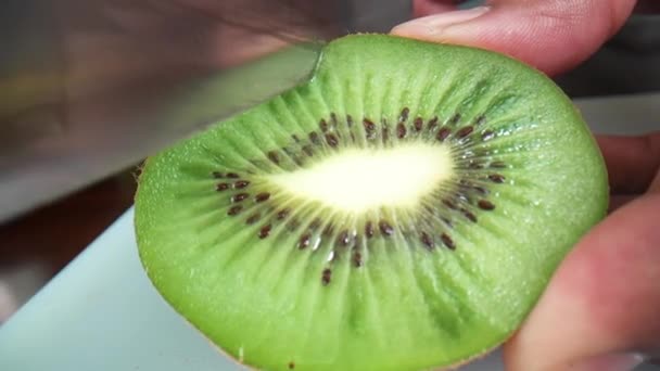 Cortar el kiwi en la mesa — Vídeo de stock