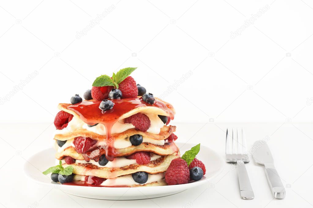 The stack of pancakes on plate with fresh berries. Light background, copy space.
