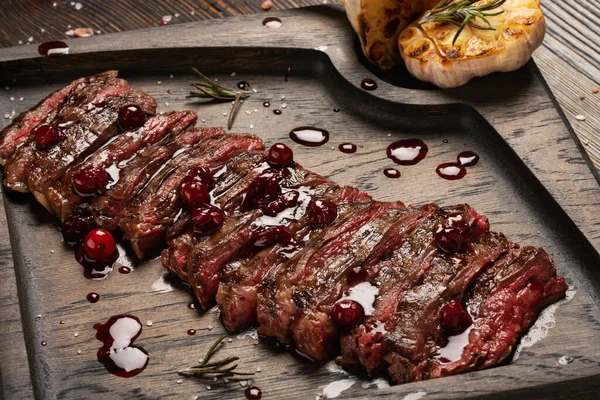 优质黑安格斯牛排配红莓酱和烤大蒜在木板上 中等程度牛排甜度 — 图库照片
