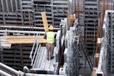 İşçi beton döşeme üzerine ahşap döşeme taşıyor.