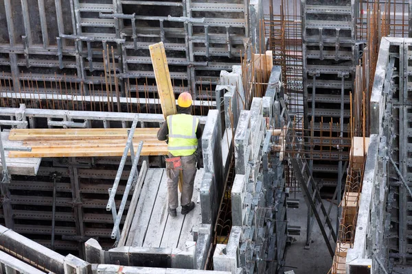 İşçi beton döşeme üzerine ahşap döşeme taşıyor.