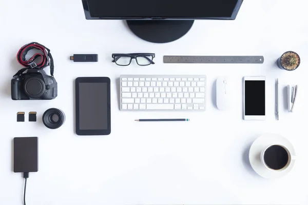 White desk office with laptop, smartphone and other work supplies with cup of coffee. Top view with copy space for input the text. Designer workspace on desk table essential elements on flat lay.