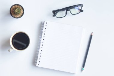 Bilgisayarlı beyaz masa ofisi, akıllı telefon ve bir fincan kahveli diğer iş malzemeleri. Metni kopyalamak için üst görünümü kullan. Desenci çalışma alanı düz masa üzerinde temel elementler yatıyordu.